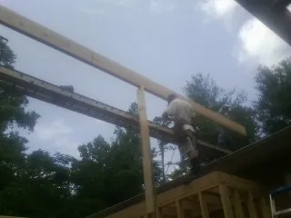 Carpenter setting a ridge beam over a new addition frame — Ice Dam Removal by Roofing Brothers in Silsbee